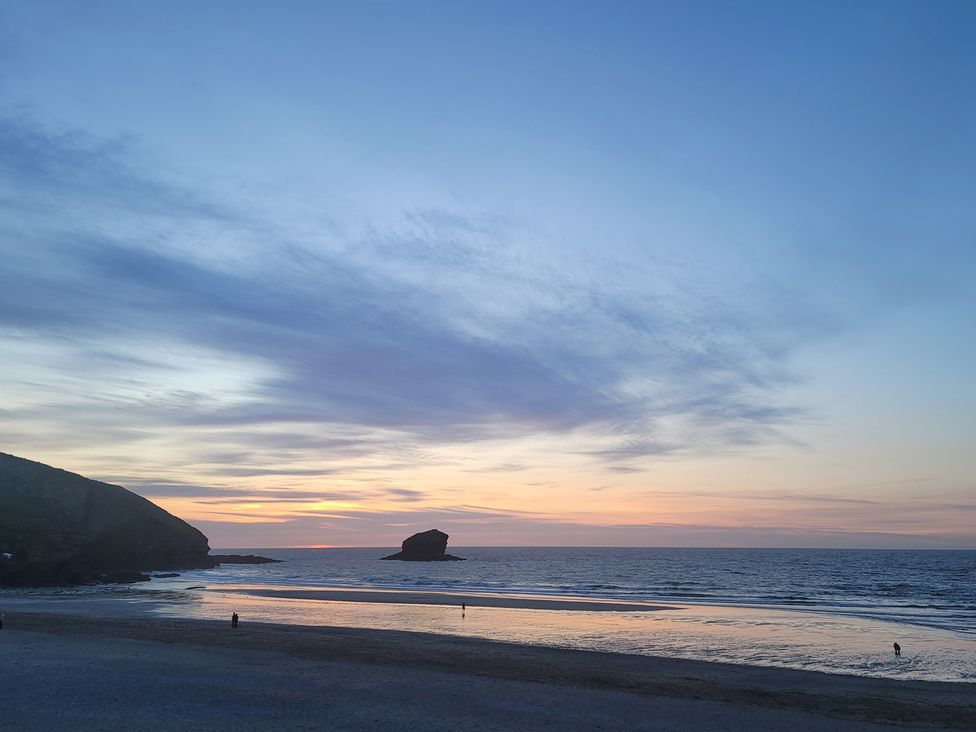 A beach scene with a rock and people at 16 Forth An Nance Portreath