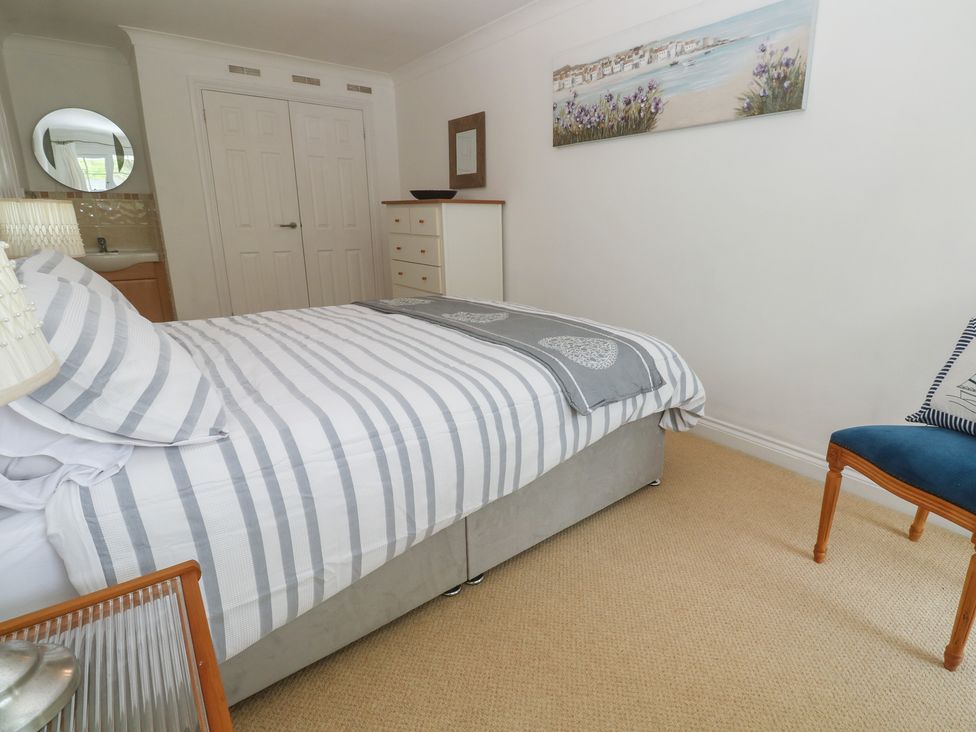 A bedroom with a bed and a chair at 16 Forth An Nance in Portreath
