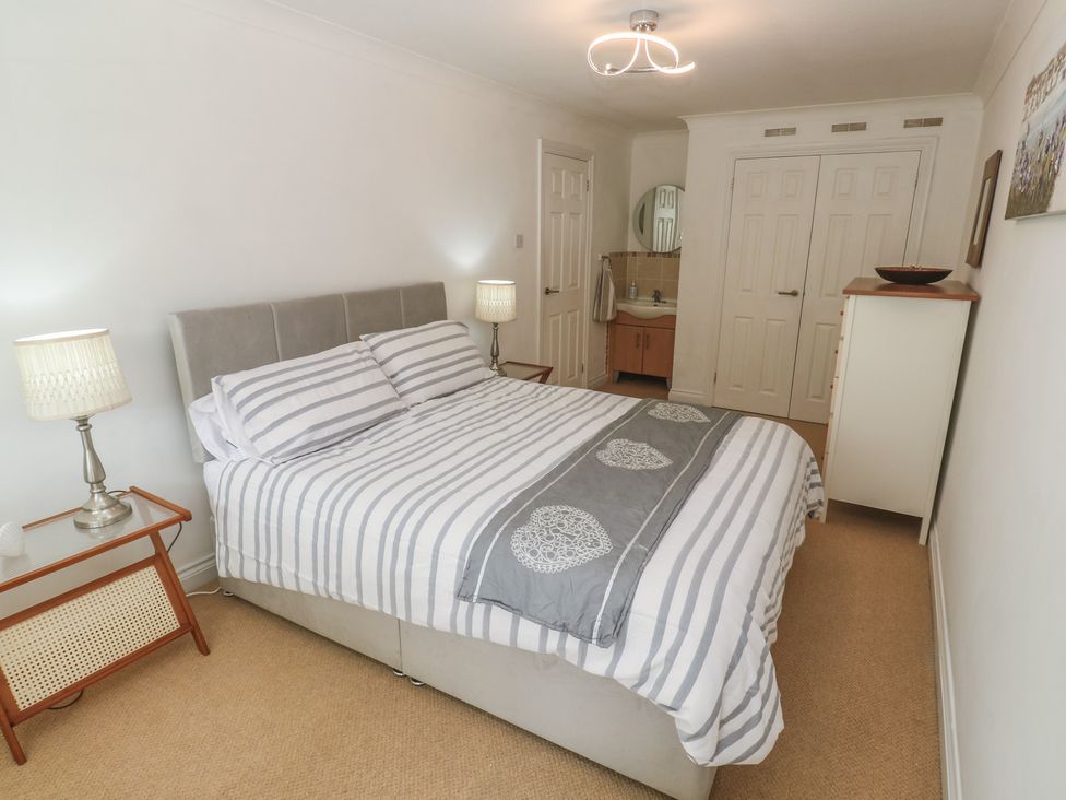 A bedroom with a bed and a wardrobe at 16 Forth An Nance in Portreath