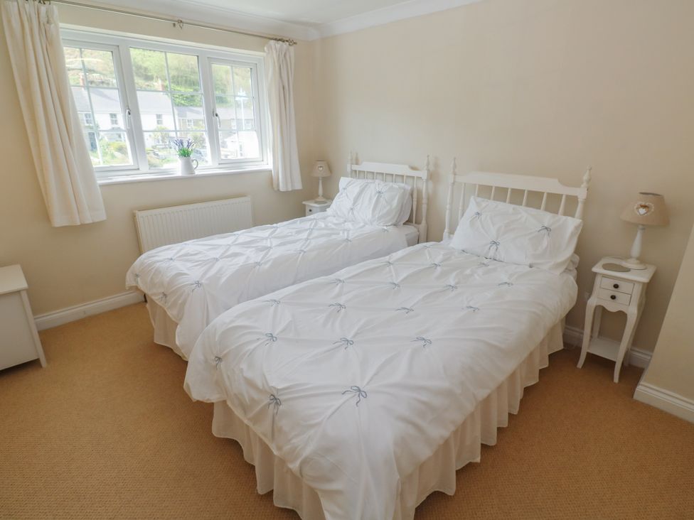 A bedroom with two single beds and a bedside table at 16 Forth An Nance in Portreath