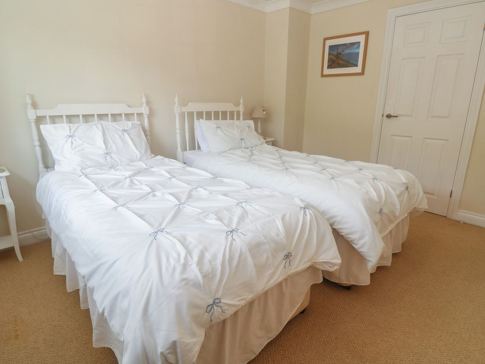 A bedroom with two single beds and a bedside table at 16 Forth An Nance in Portreath