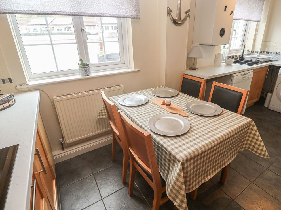 A kitchen with a table and chairs at 16 Forth An Nance in Portreath