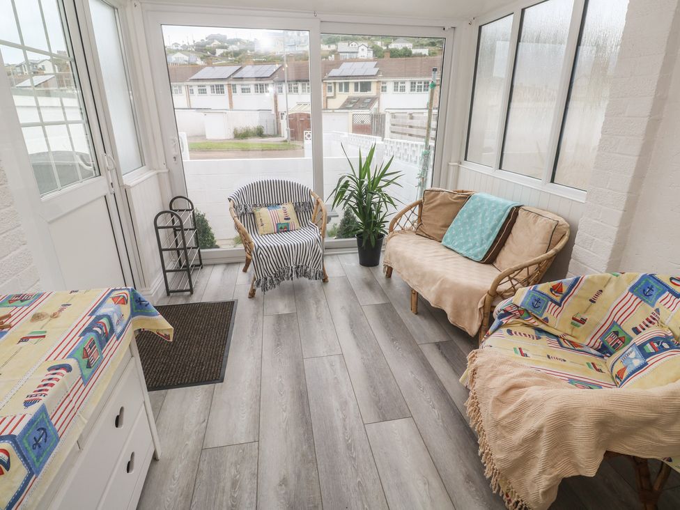 A conservatory with chairs and a table at 16 Forth An Nance in Portreath