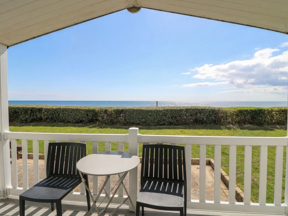 An outdoor area with chairs and a table overlooking the sea at Caravan in Great Yarmouth