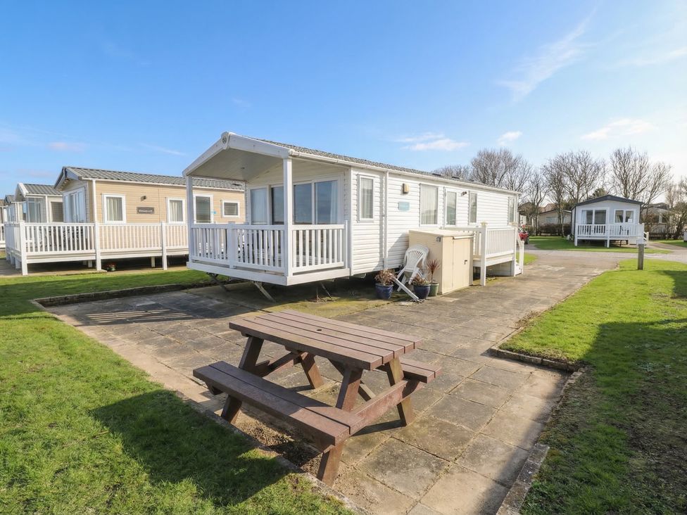 A caravan with seating area in front at Caravan in Great Yarmouth