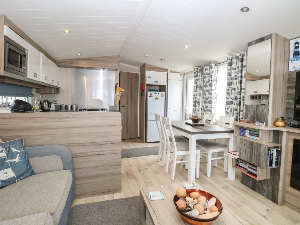 A living room with a kitchen area and dining table at Caravan in Great Yarmouth