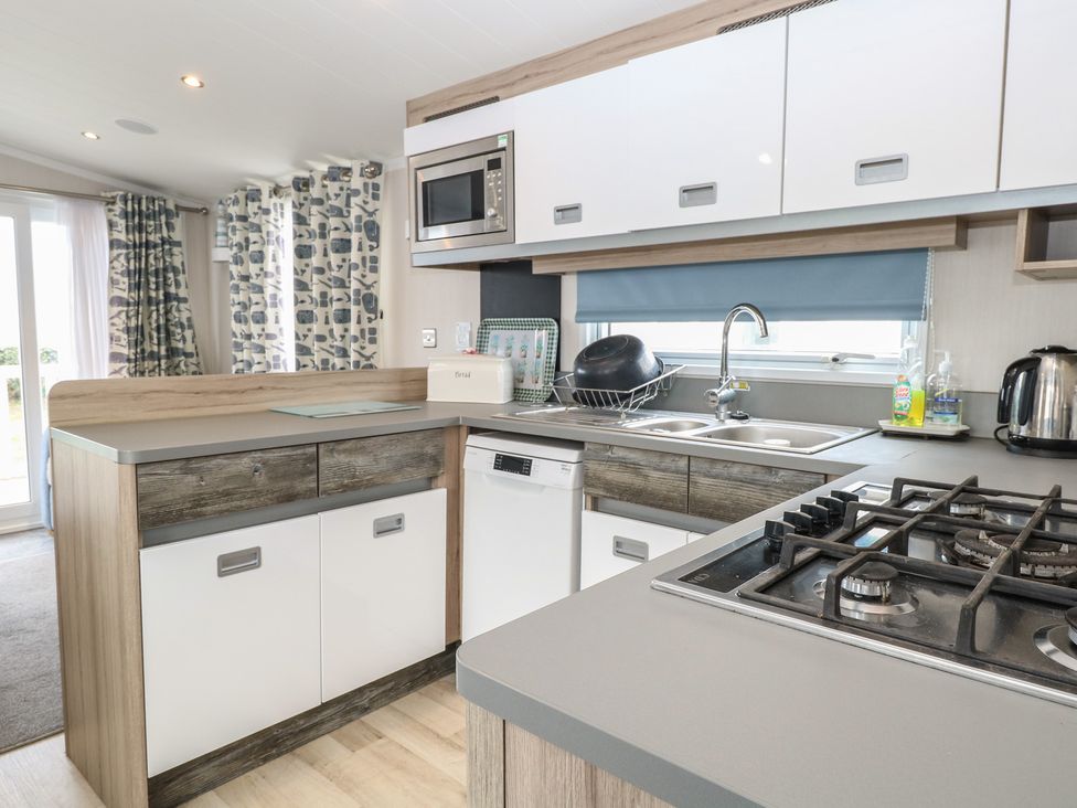 A kitchen with sink and gas stove at Caravan in Great Yarmouth