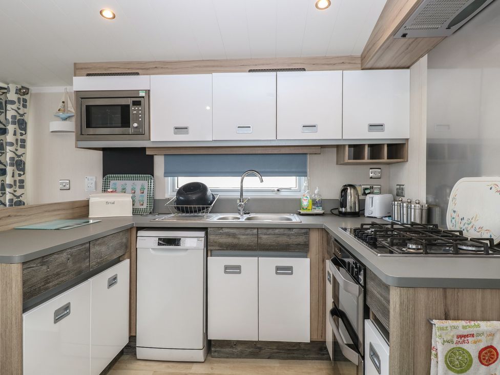 A kitchen with cabinets and appliances at Caravan in Great Yarmouth