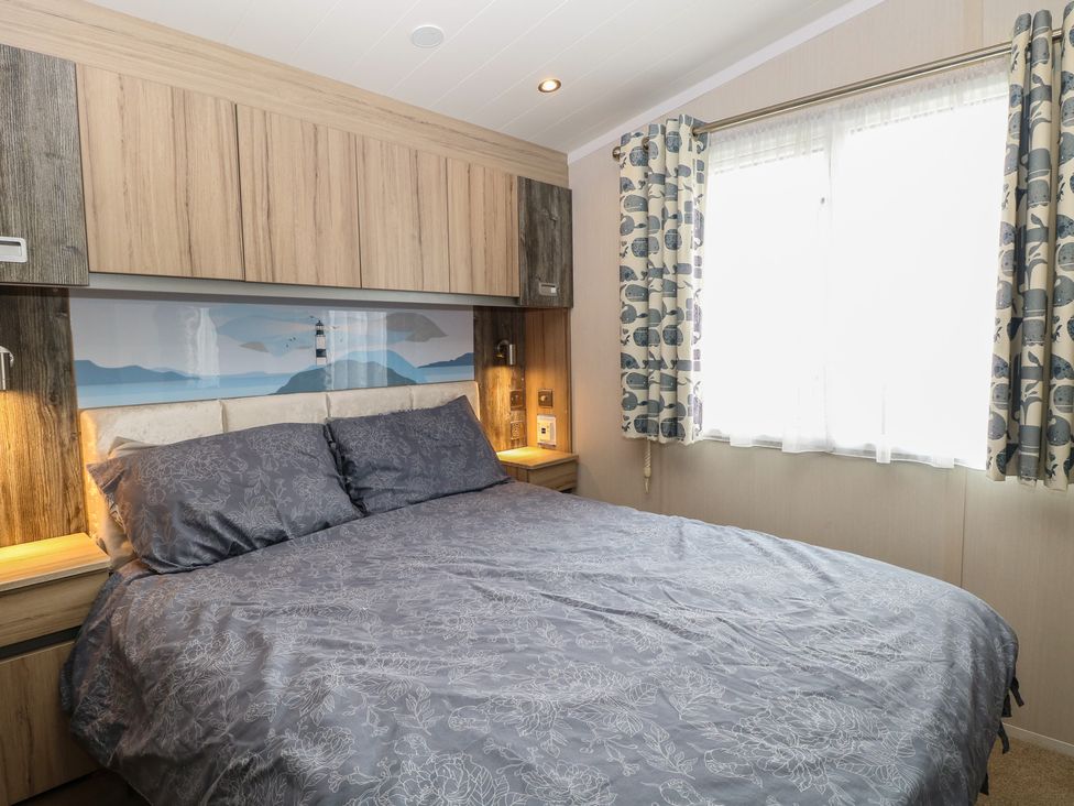 A bedroom with a bed and shelves at Caravan in Great Yarmouth