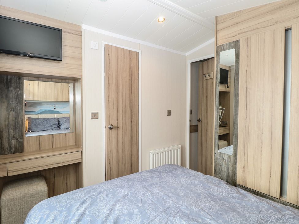 A bedroom with a bed and a television in Caravan at Great Yarmouth