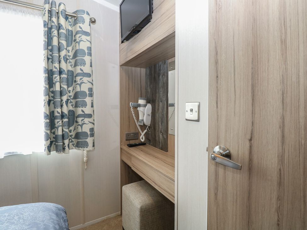 A bedroom with a television and a phone at Caravan in Great Yarmouth