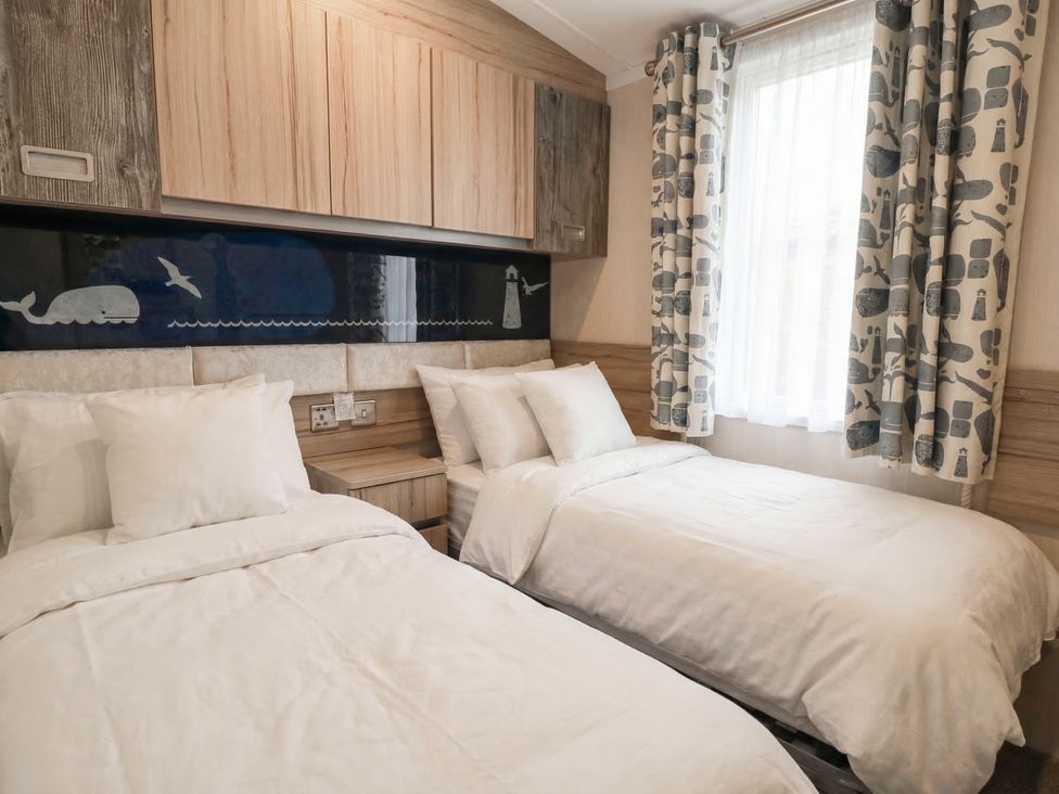 A bedroom with two beds and curtains at Caravan in Great Yarmouth