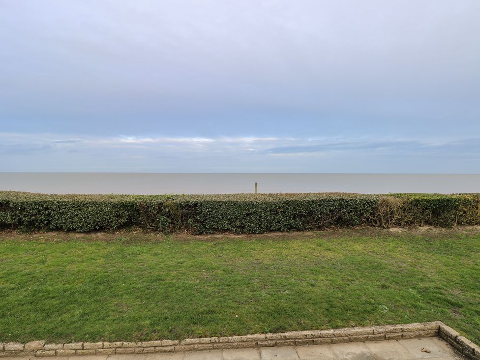 A view of the sea with grass and a hedge at Caravan in Great Yarmouth
