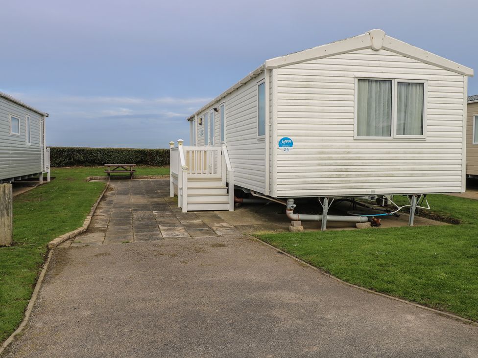 A caravan with a patio area and a table at Caravan in Great Yarmouth