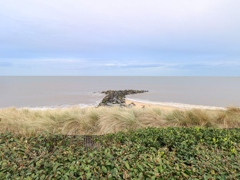 A view of the sea with rocks and sand at a coastal area in Great Yarmouth