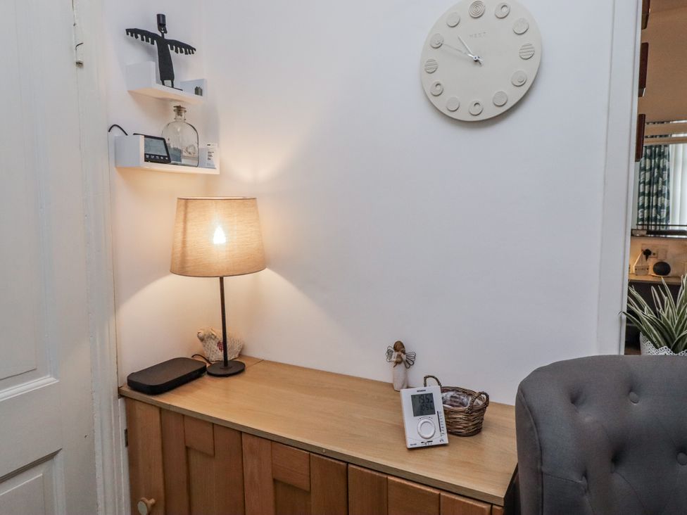 A hallway with a lamp and clock on a wooden cabinet at 55 Meldon terrace Newbiggin-by-the-Sea