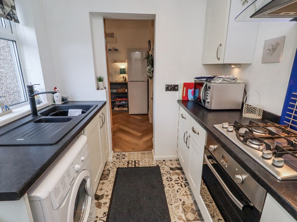 A kitchen with a sink and gas stove at 55 Meldon terrace in Newbiggin-by-the-Sea