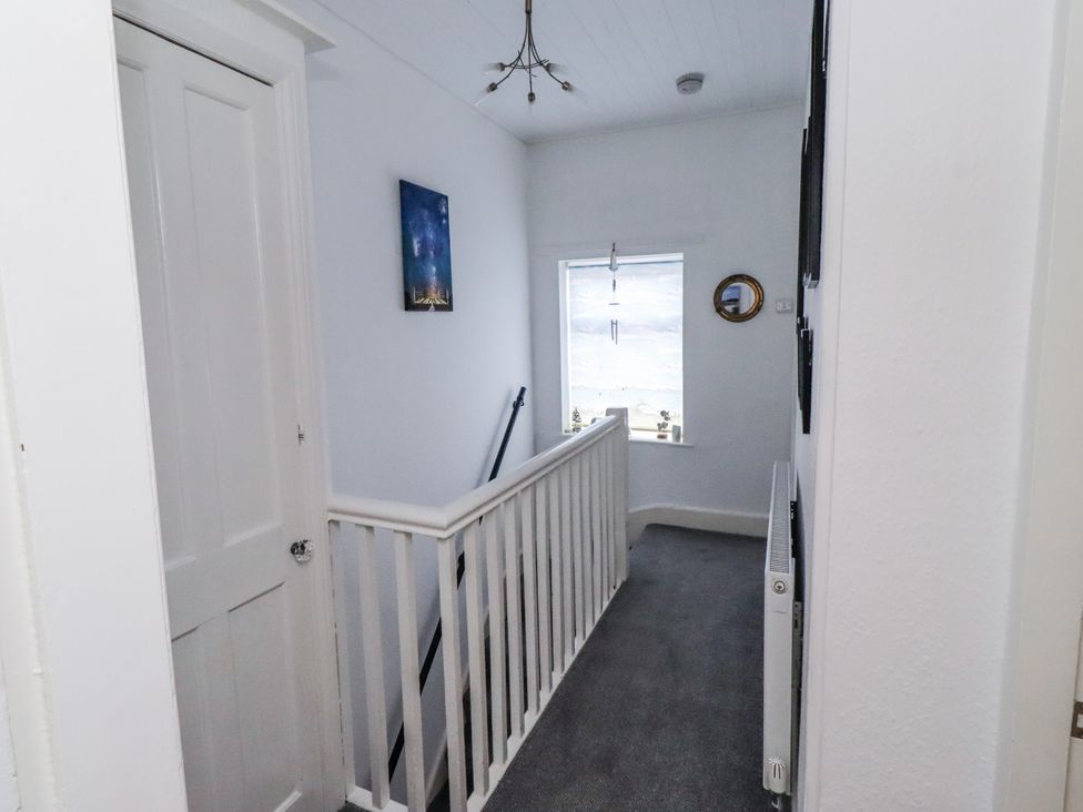 A hallway with a staircase and a window at 55 Meldon terrace Newbiggin-by-the-Sea