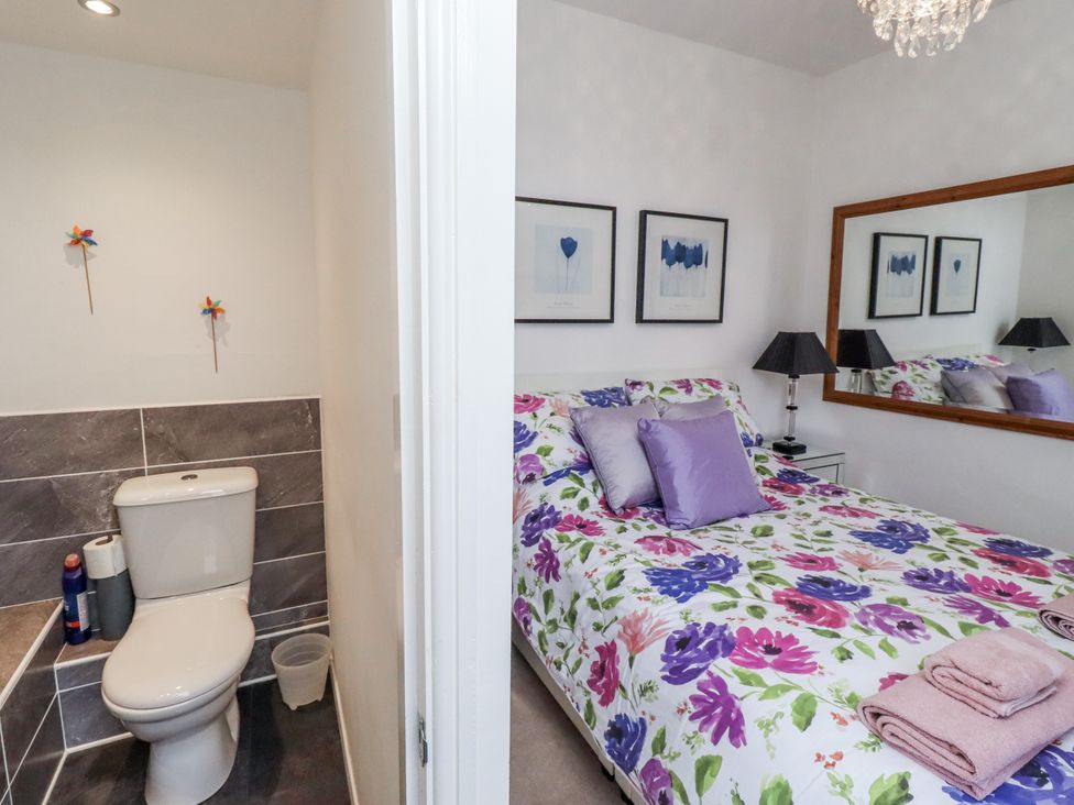 A bedroom with a bed and a bathroom featuring a toilet at 55 Meldon terrace Newbiggin-by-the-Sea