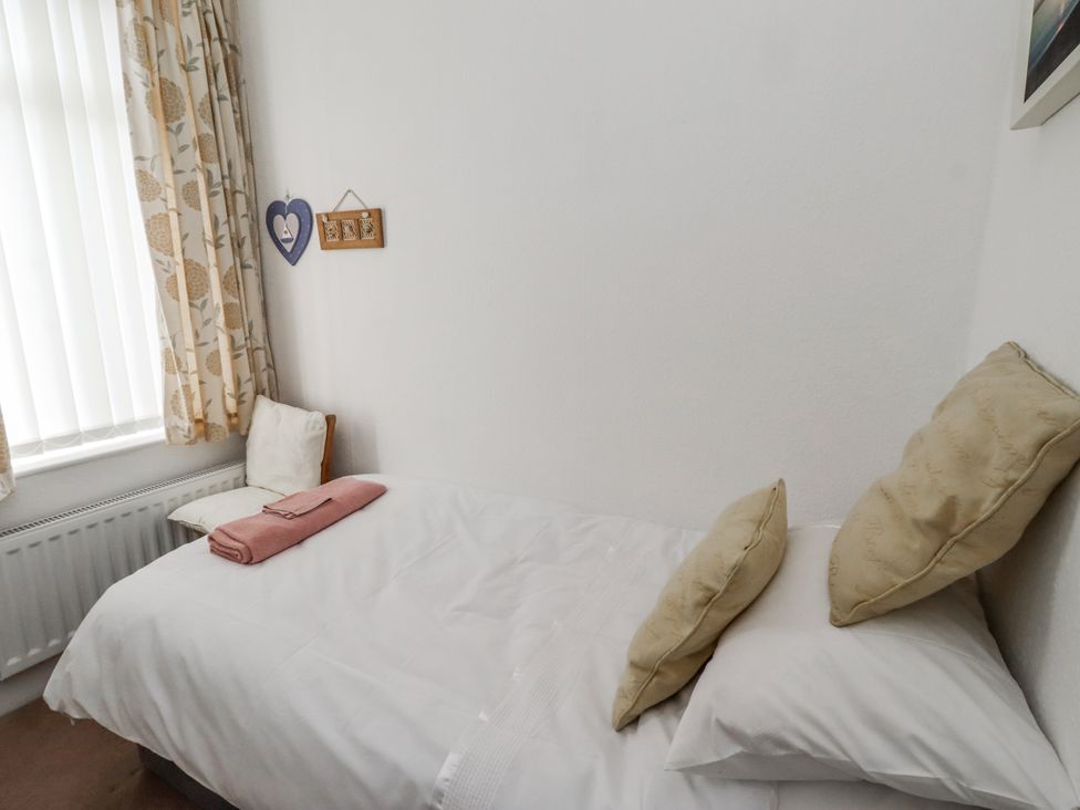 A bedroom with a bed and chair at 55 Meldon terrace Newbiggin-by-the-Sea