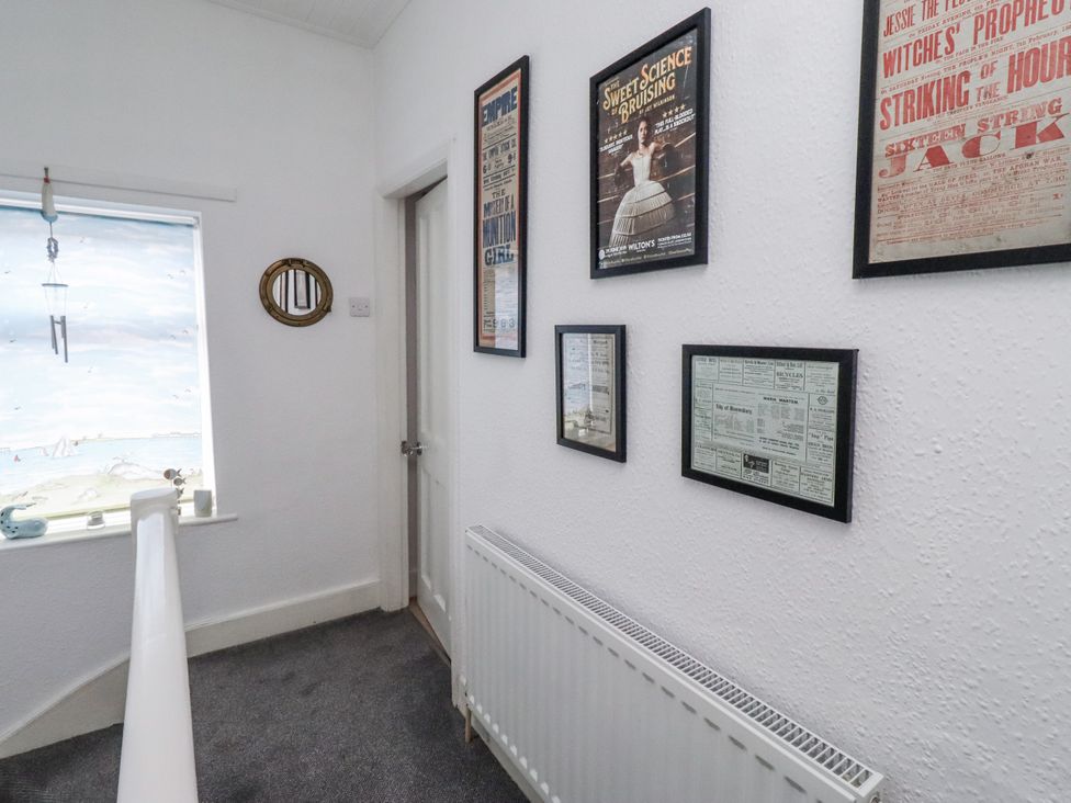 A hallway with framed posters and a window at 55 Meldon terrace Newbiggin-by-the-Sea