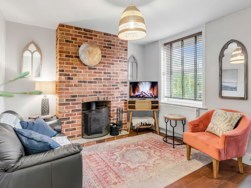 A living room with a fireplace and a television at Bay Tree Cottage in Heacham
