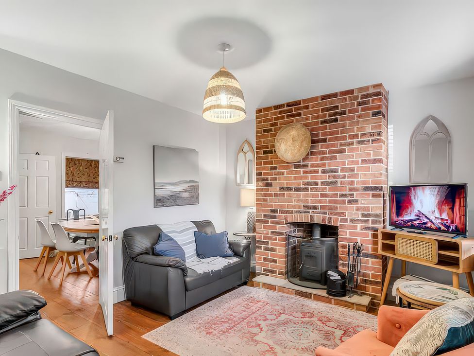 A living room with a fireplace and television at Bay Tree Cottage in Heacham