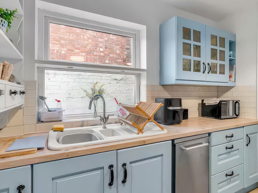 A kitchen with a sink and drying rack at Bay Tree Cottage in Heacham