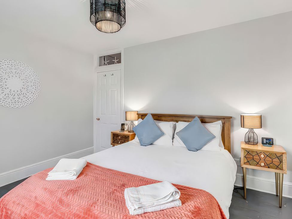 A bedroom with a bed and nightstand at Bay Tree Cottage in Heacham