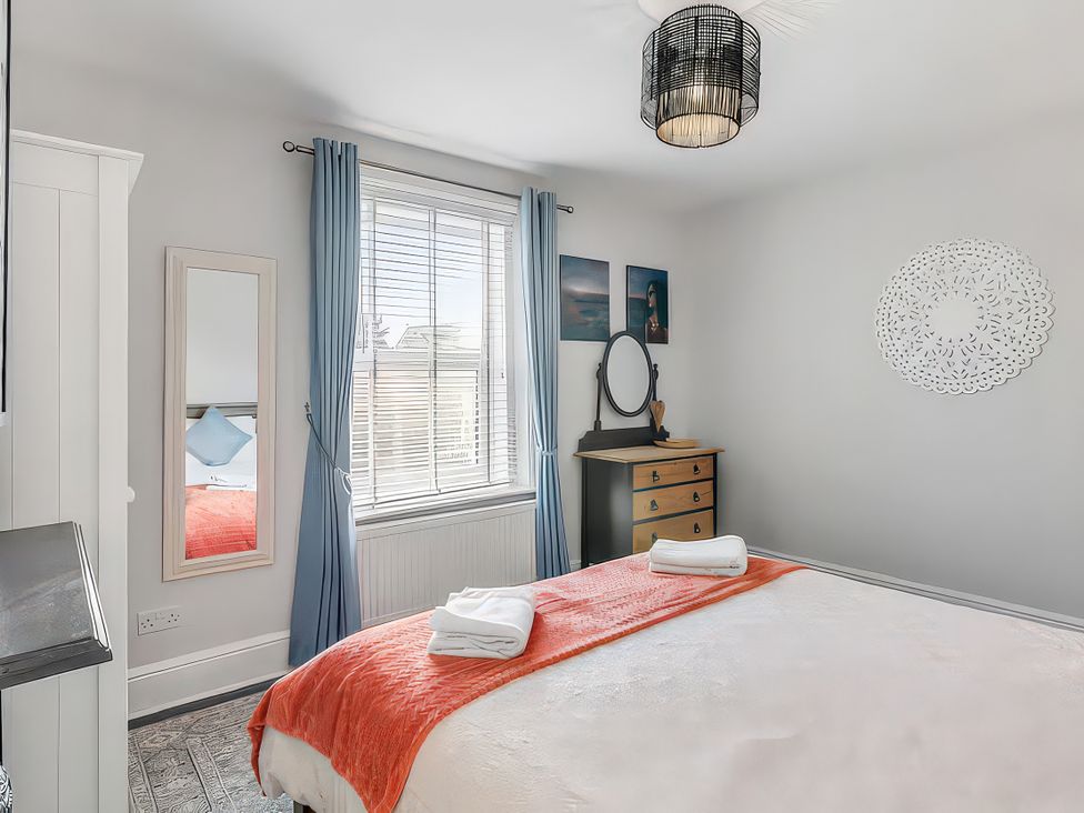 A bedroom with a bed and dresser at Bay Tree Cottage in Heacham