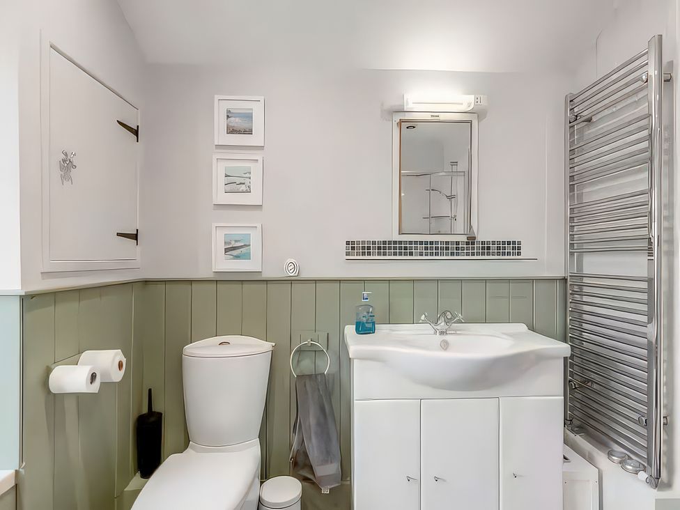 A bathroom with a toilet, sink, and towel radiator at Bay Tree Cottage in Heacham