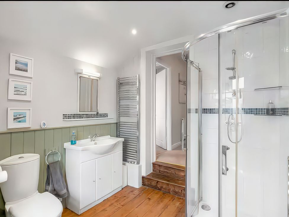 A bathroom with a sink, toilet, and shower at Bay Tree Cottage in Heacham