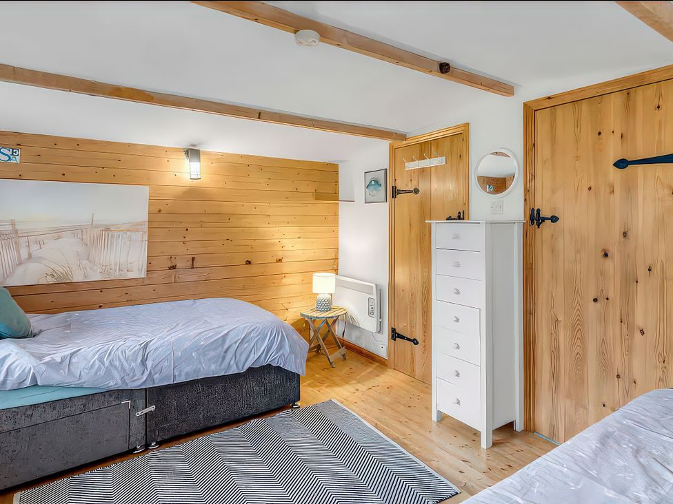 A bedroom with two beds and a dresser at Bay Tree Cottage in Heacham