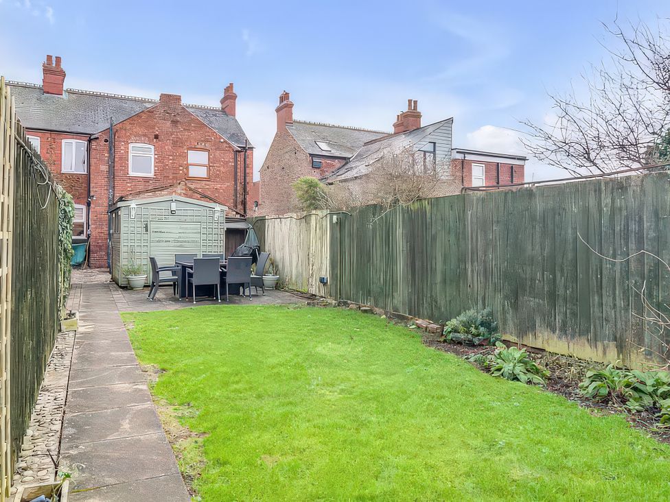 A garden with a shed and outdoor furniture at Bay Tree Cottage in Heacham