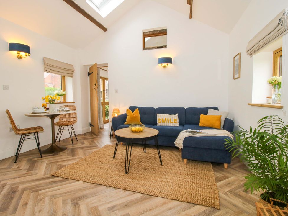 A living room with a sofa and dining table at The Blacksmiths Shop in 