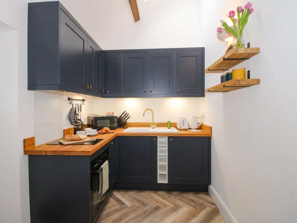 A kitchen with cabinets and countertop at The Blacksmiths Shop in 