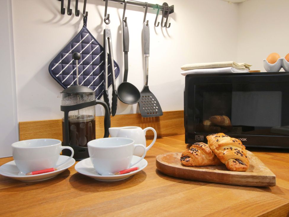 A kitchen with coffee maker and pastries on a counter at The Blacksmiths Shop