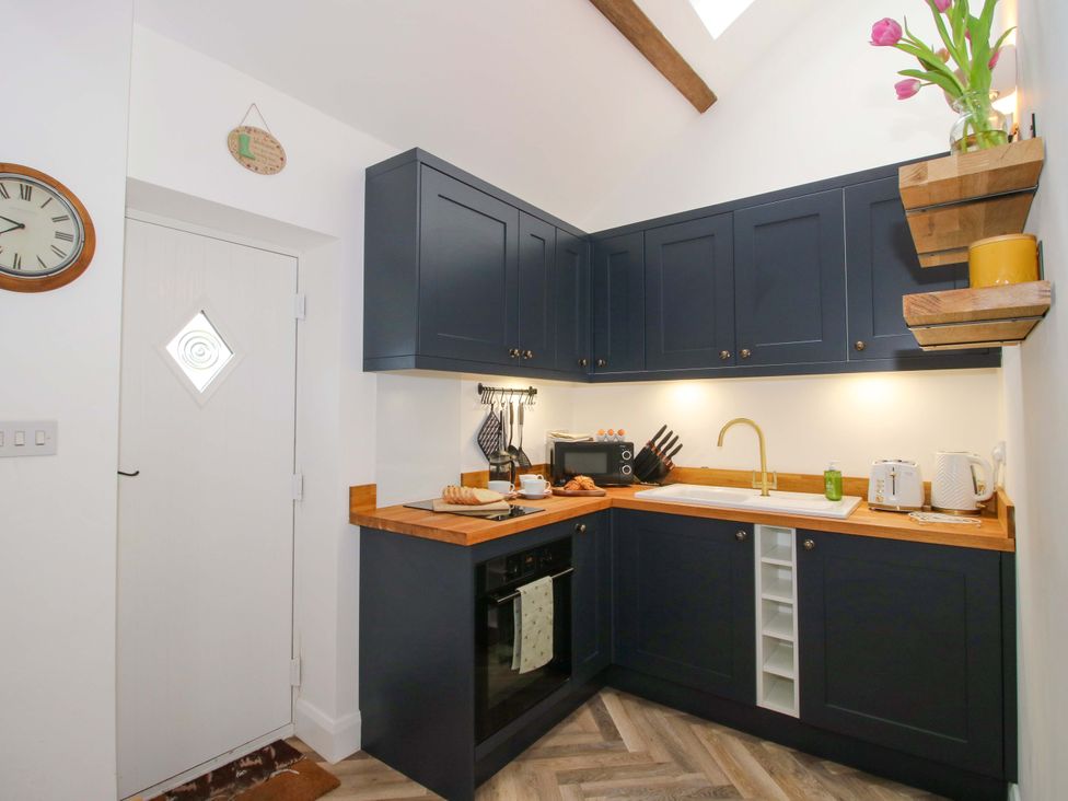 A kitchen with cabinets and appliances at The Blacksmiths Shop in 