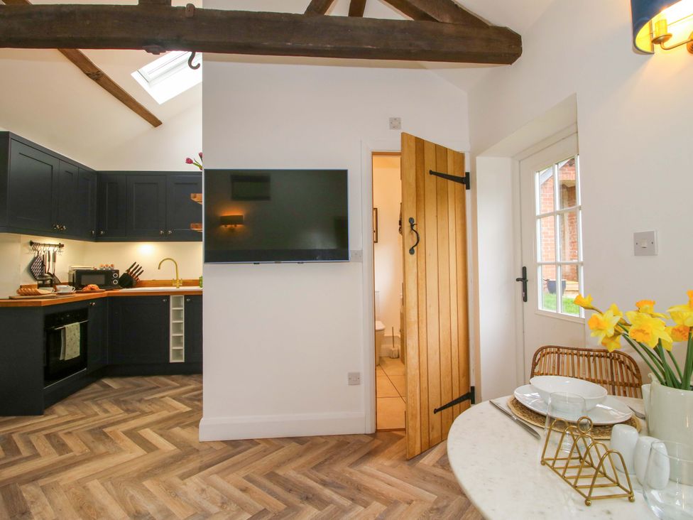 A kitchen with a wooden door and a television at The Blacksmiths Shop in 