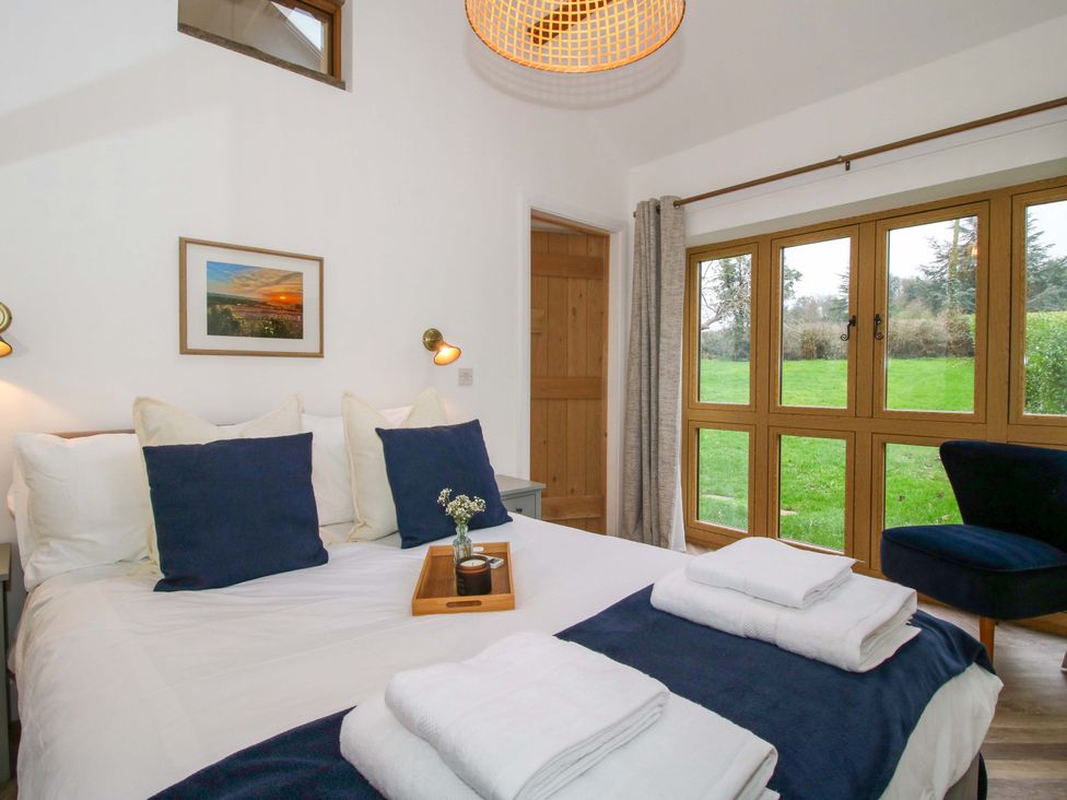 A bedroom with a bed and windows at The Blacksmiths Shop in 