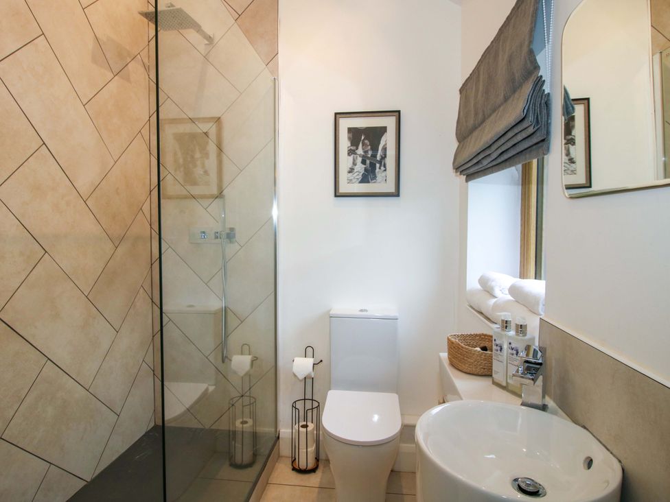 A bathroom with a shower, toilet, and sink at The Blacksmiths Shop