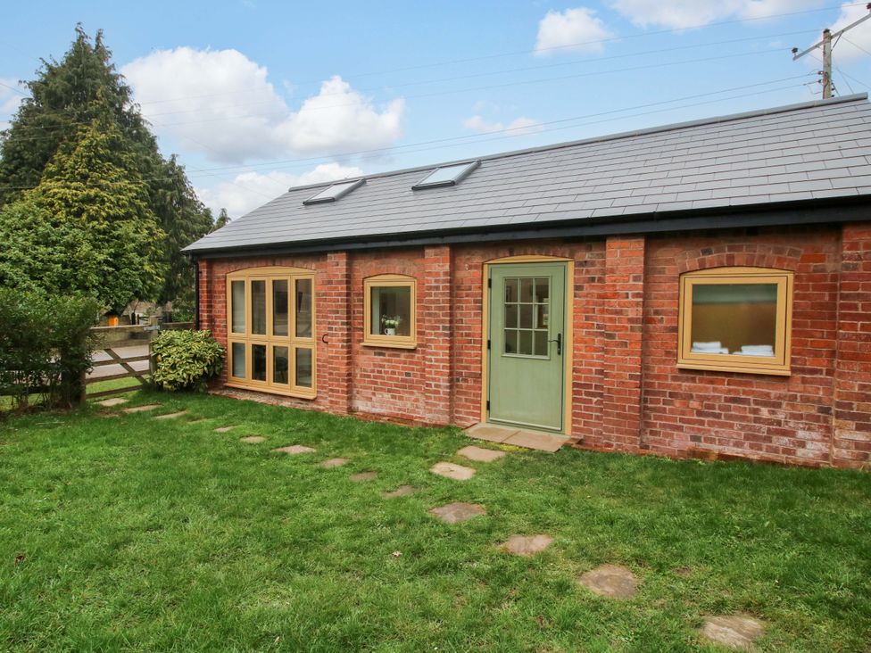 An outdoor area with a brick wall building and garden path at The Blacksmiths Shop in 
