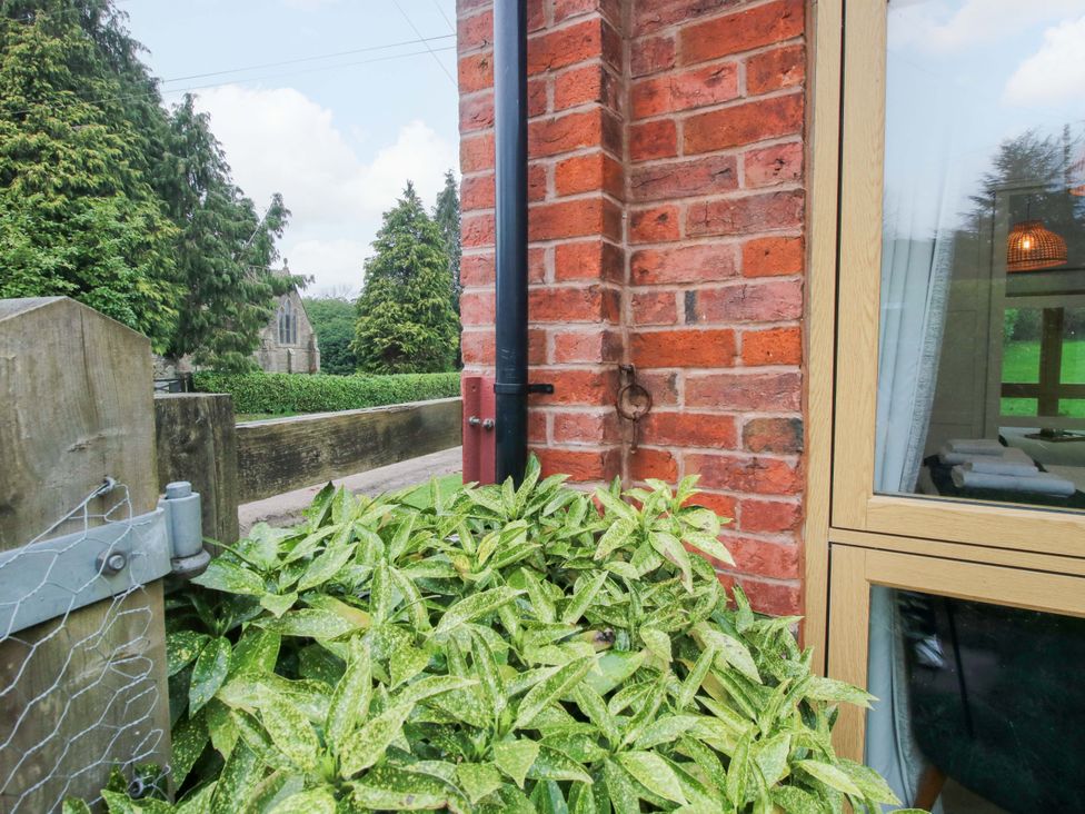 A brick wall with a window and plants at The Blacksmiths Shop in 