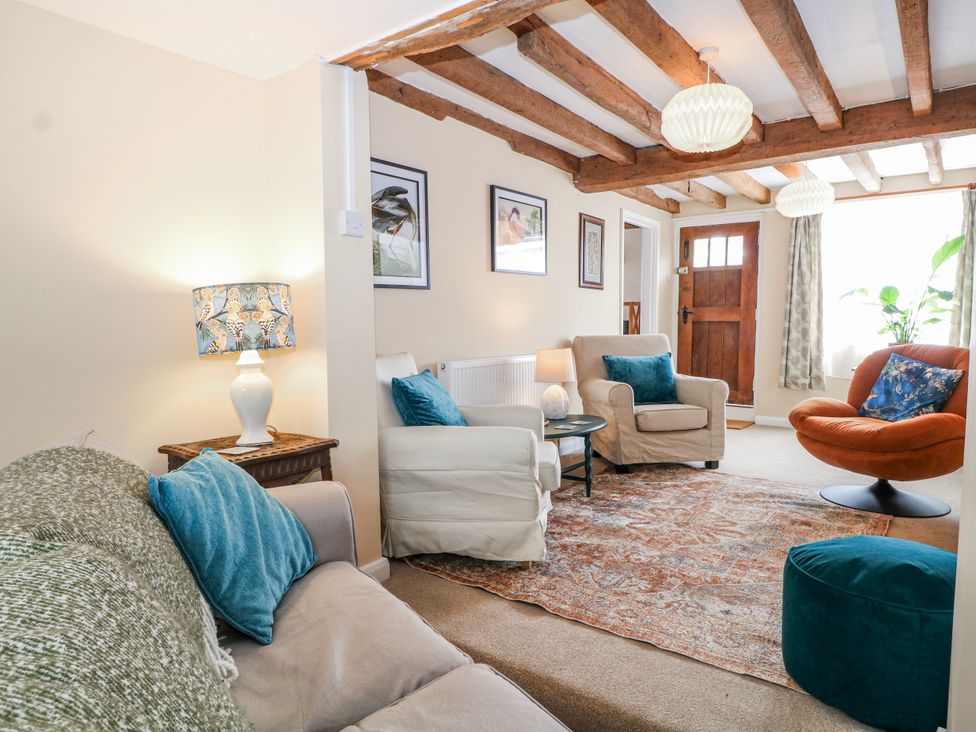 A living room with chairs and a table at 7 Chapel Hill Quinc Cottage Lewes