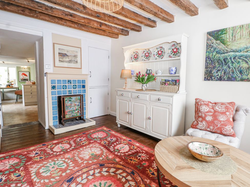 A living room with a fireplace and cabinet at 7 Chapel Hill Quinc Cottage in Lewes