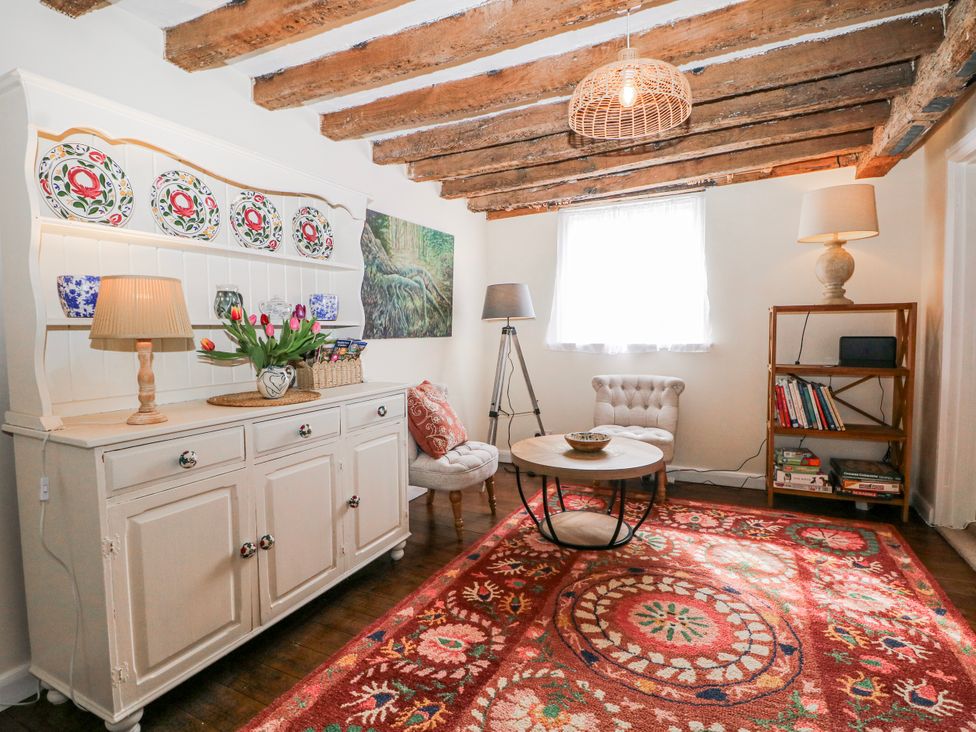 A living room with a coffee table and shelves at 7 Chapel Hill Quinc Cottage in Lewes