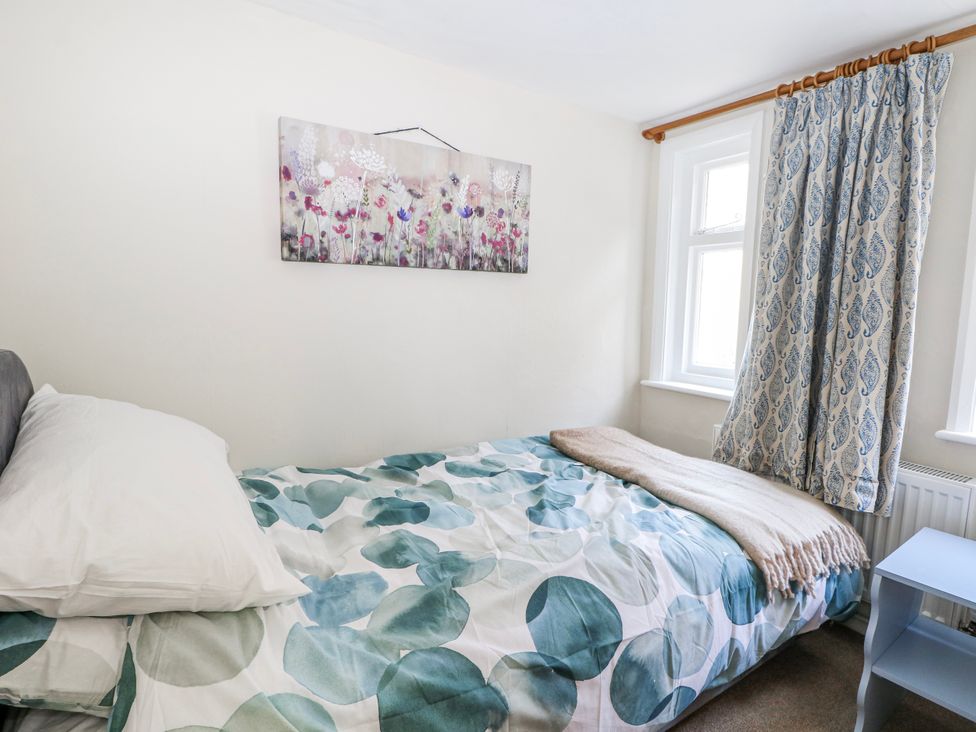 A bedroom with a bed and window at 7 Chapel Hill Quinc Cottage Lewes