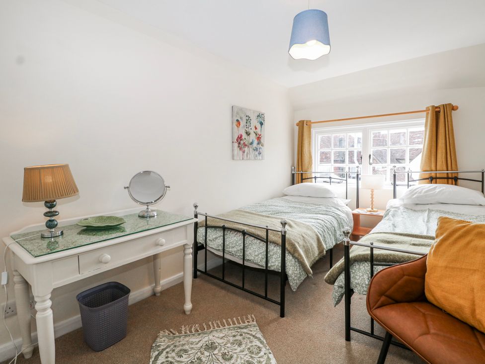 A bedroom with two beds and a desk at 7 Chapel Hill Quinc Cottage Lewes