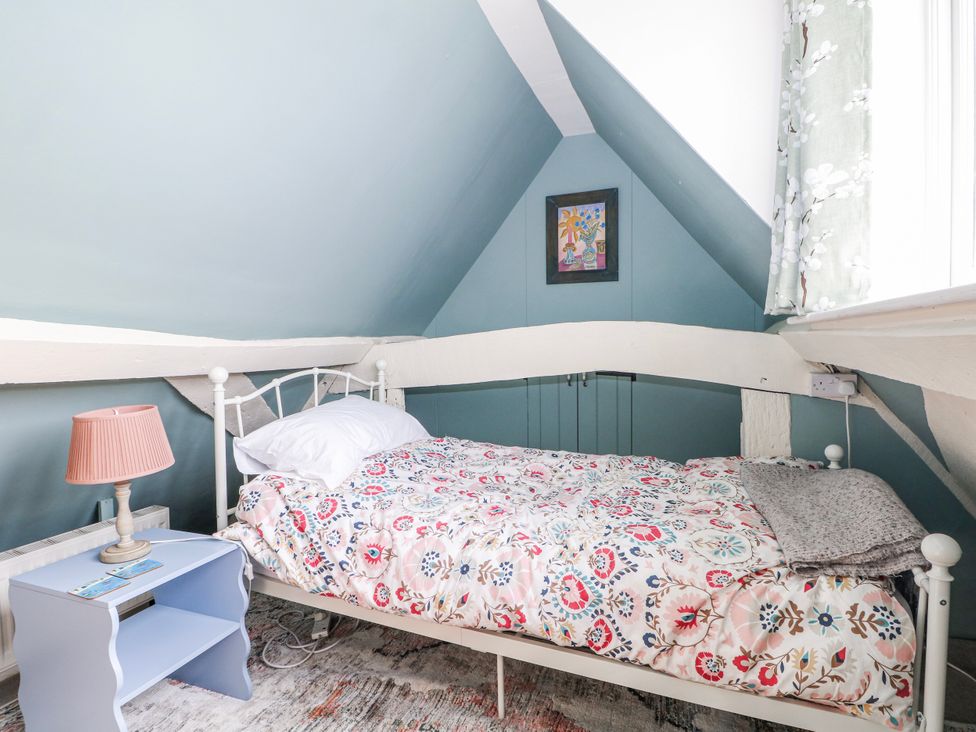 A bedroom with a bed and a lamp at 7 Chapel Hill Quinc Cottage Lewes