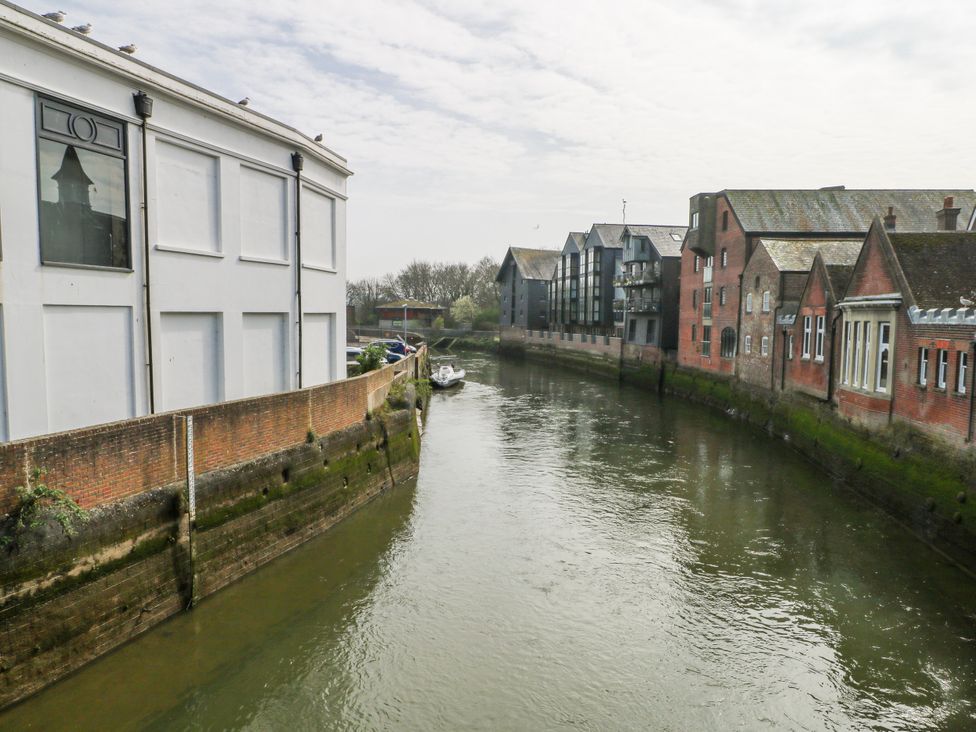 A view of buildings by a river at 7 Chapel Hill Quinc Cottage Lewes
